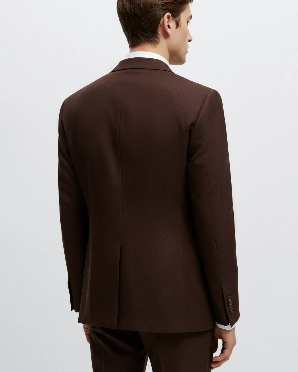 Man in a brown suit jacket and trousers, back view, against white background. Elegant and professional look.