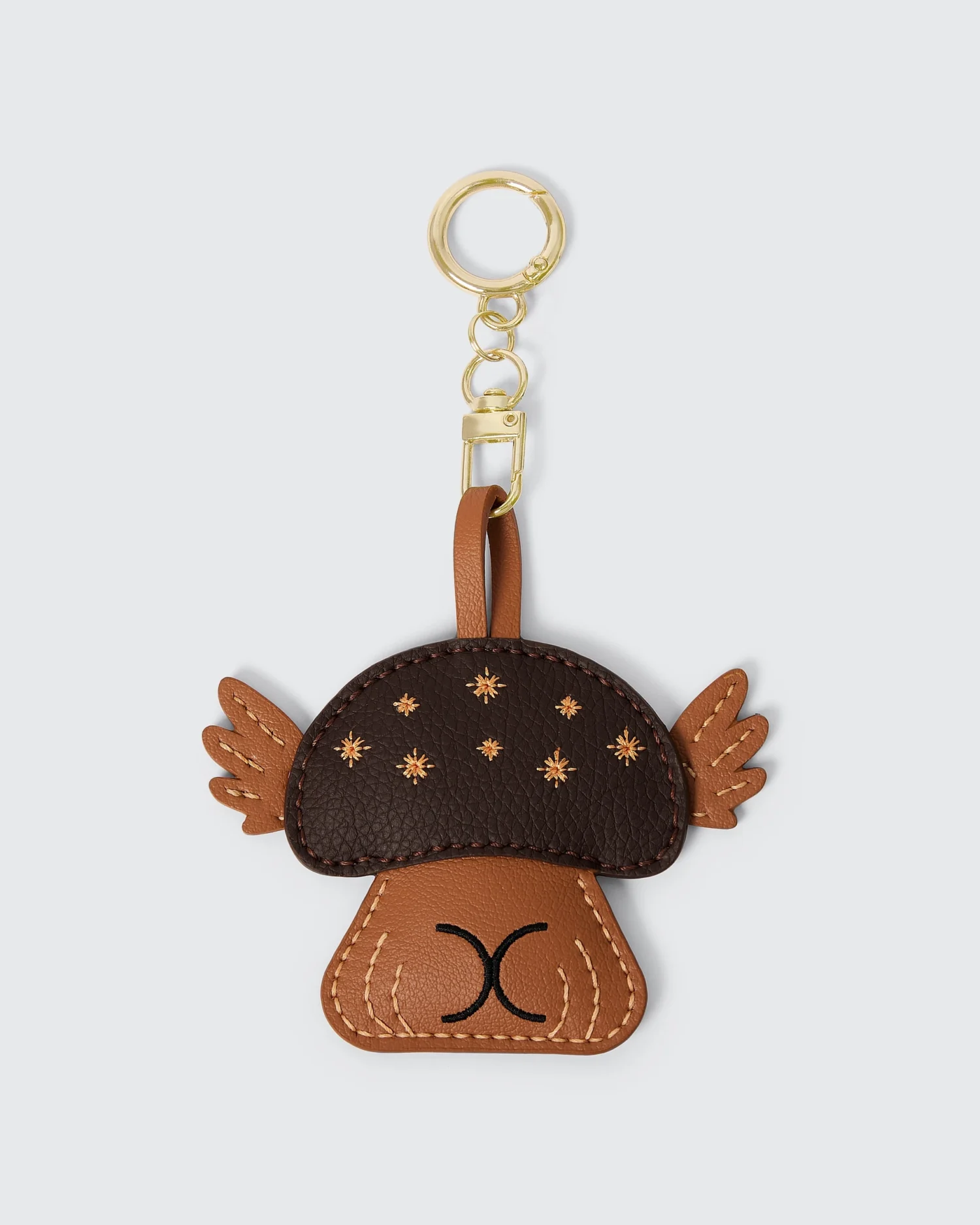 Cute mushroom-shaped vegan leather keychain with gold ring and star details, perfect accessory for bags and keys.