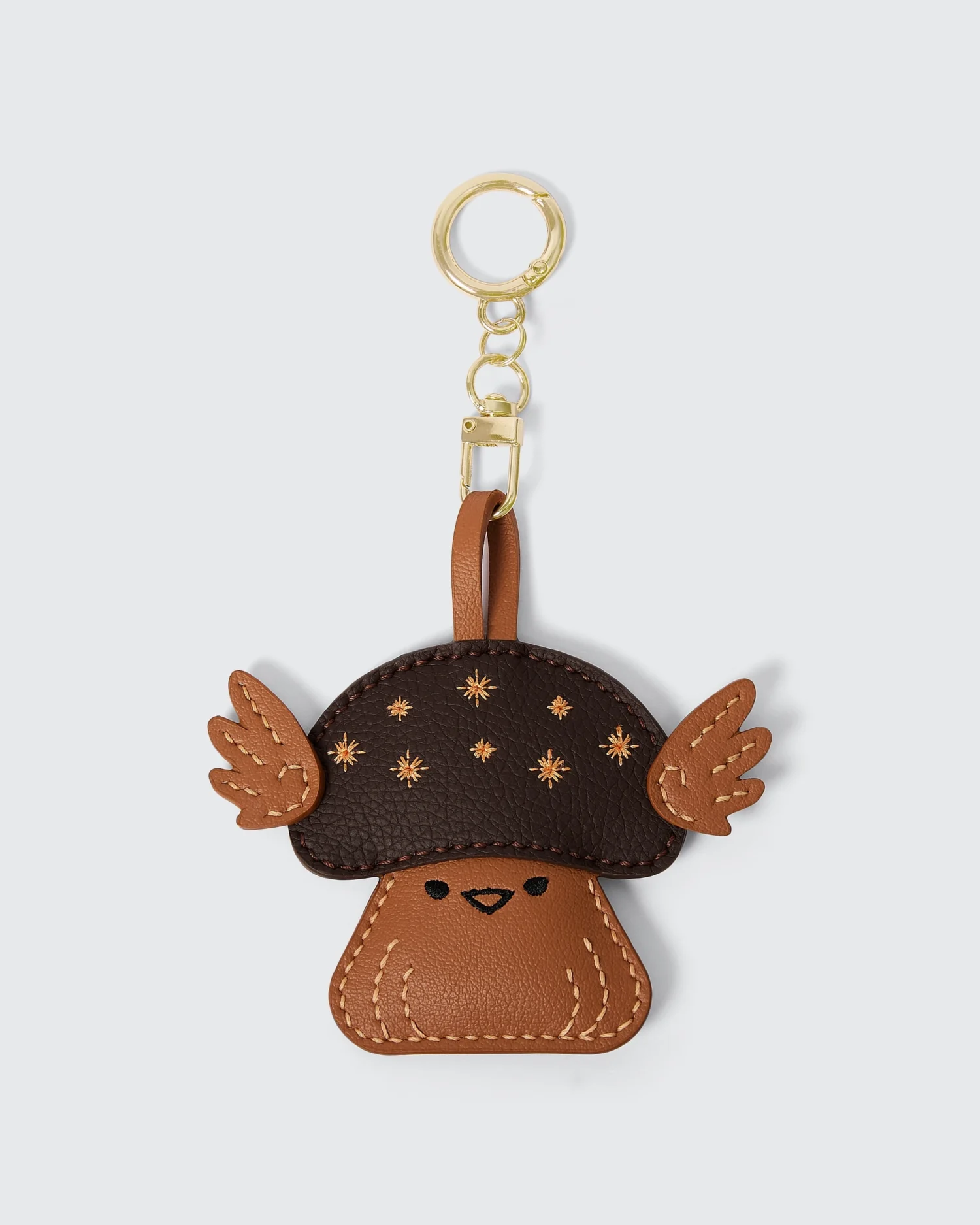 Cute mushroom keychain with star details and wings, perfect for accessorizing bags and keys.