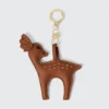 Brown deer-shaped vegan leather keychain with gold ring, featuring detailed stitching and star patterns.