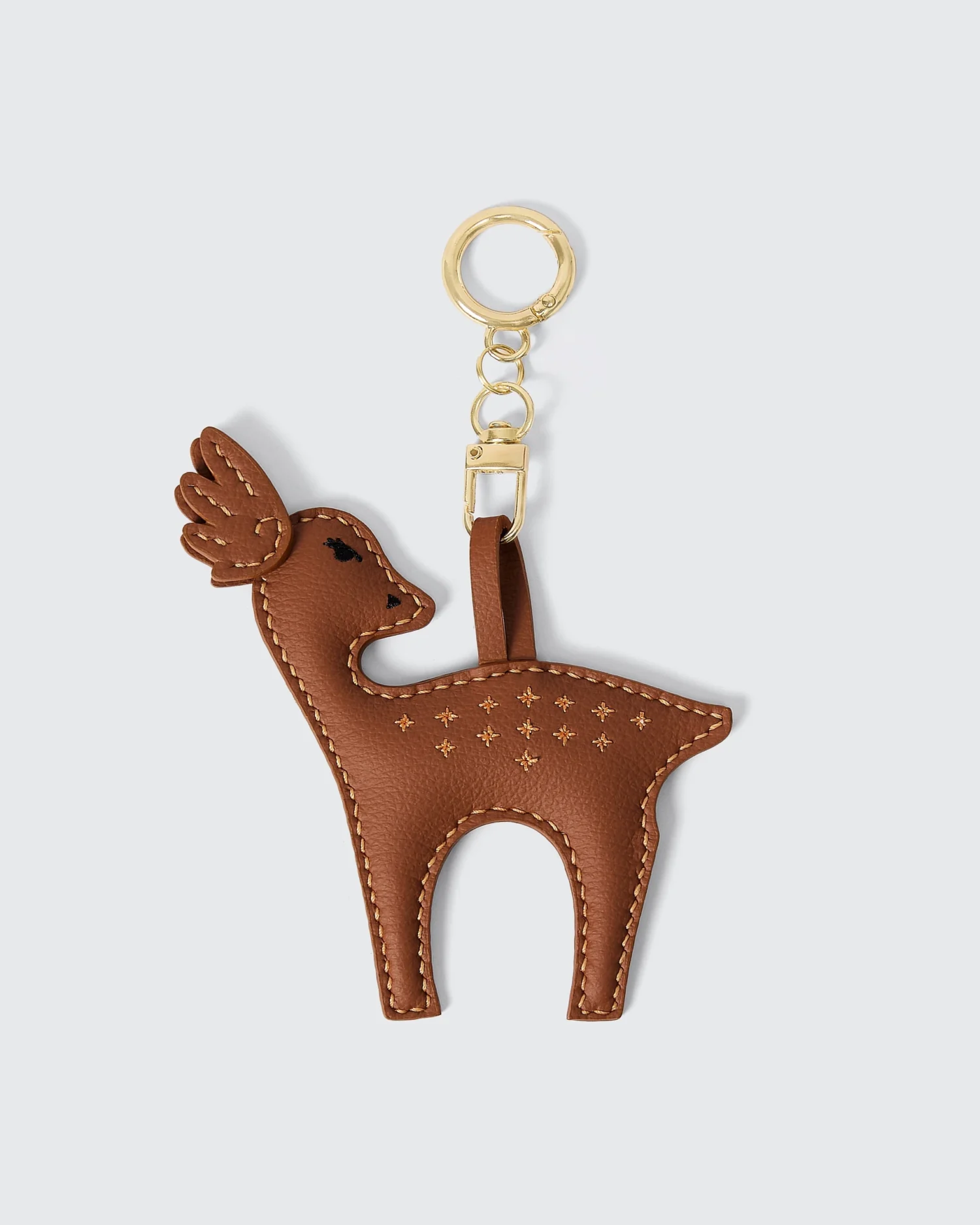 Brown deer-shaped vegan leather keychain with gold ring, featuring detailed stitching and star patterns.