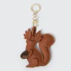 Cute vegan leather squirrel keychain with detailed stitching, holding an acorn. Perfect accessory for bags and keys.