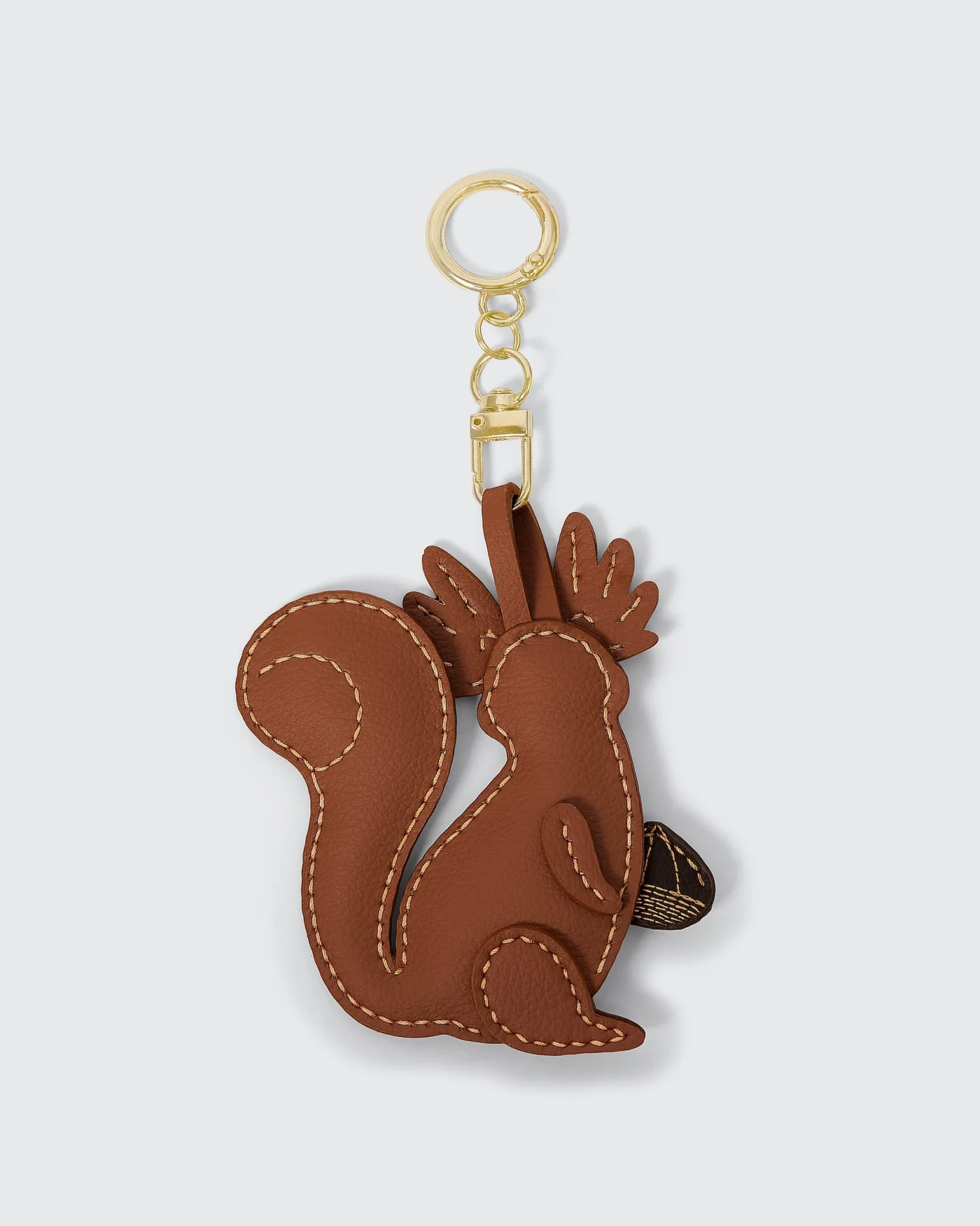 Leather squirrel keychain with gold ring and clasp, featuring detailed stitching on a light gray background.
