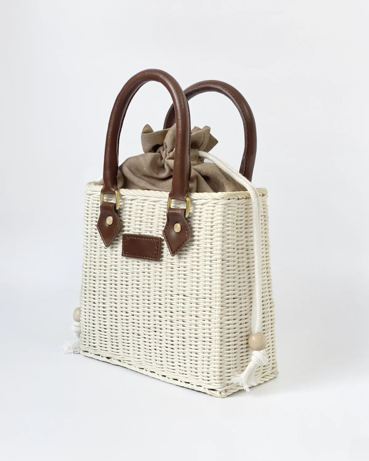 Woven ROSIE HONG handbag with brown handles and beige inner lining, featuring a stylish and elegant design for casual use.