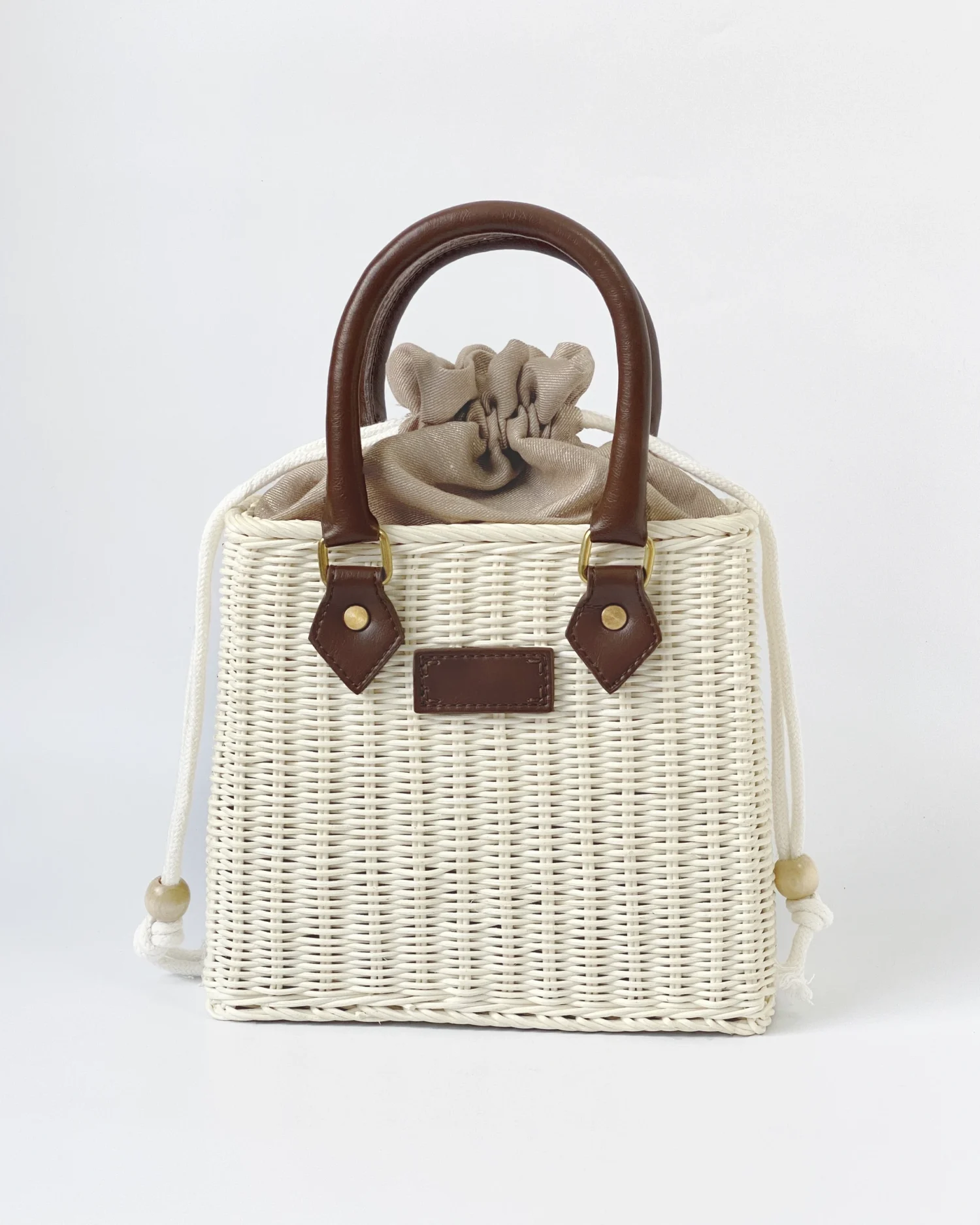 Woven ROSIE HONG handbag with leather handles and drawstring closure, featuring a stylish, natural design for summer outings.