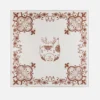 Intricate red patterned reindeer motif with floral border on elegant white background.