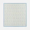 Geometric blue patterned silk scarf with intricate floral and diamond design on a light background.