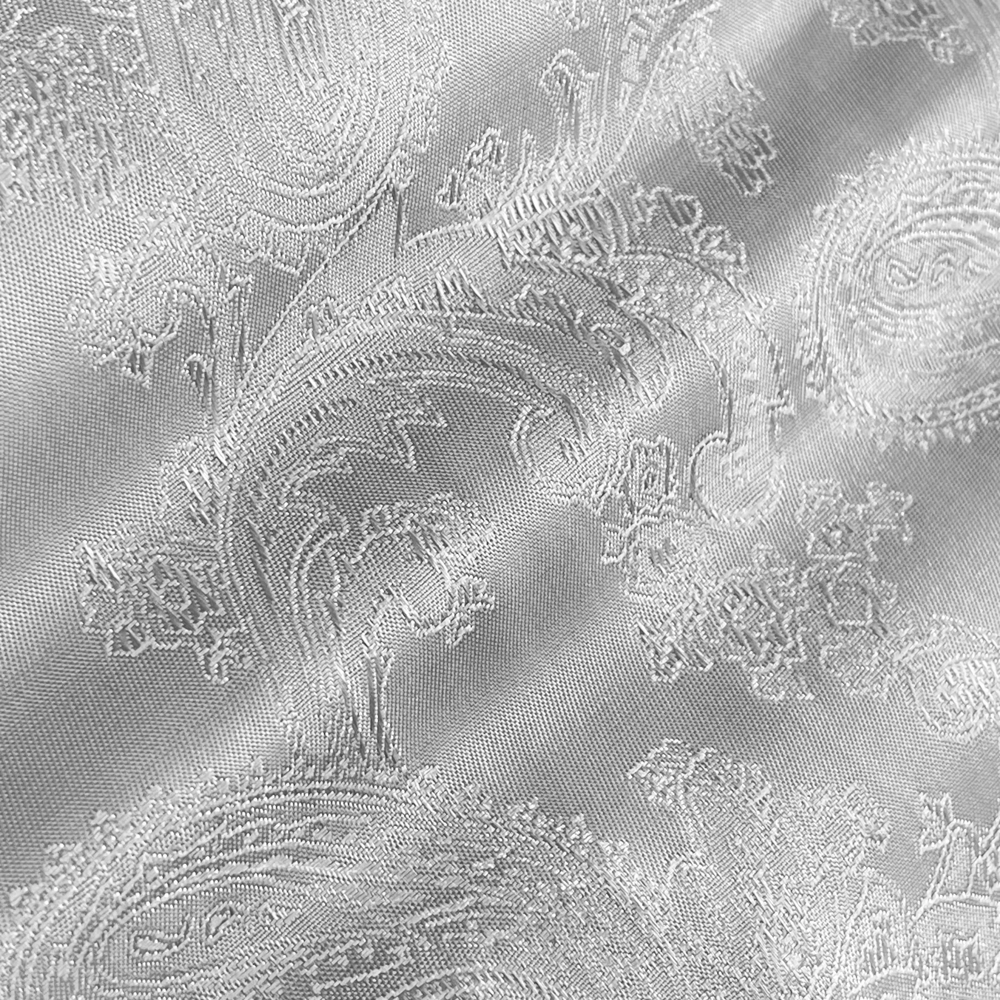 Detailed white fabric with elegant paisley pattern and intricate embroidery.