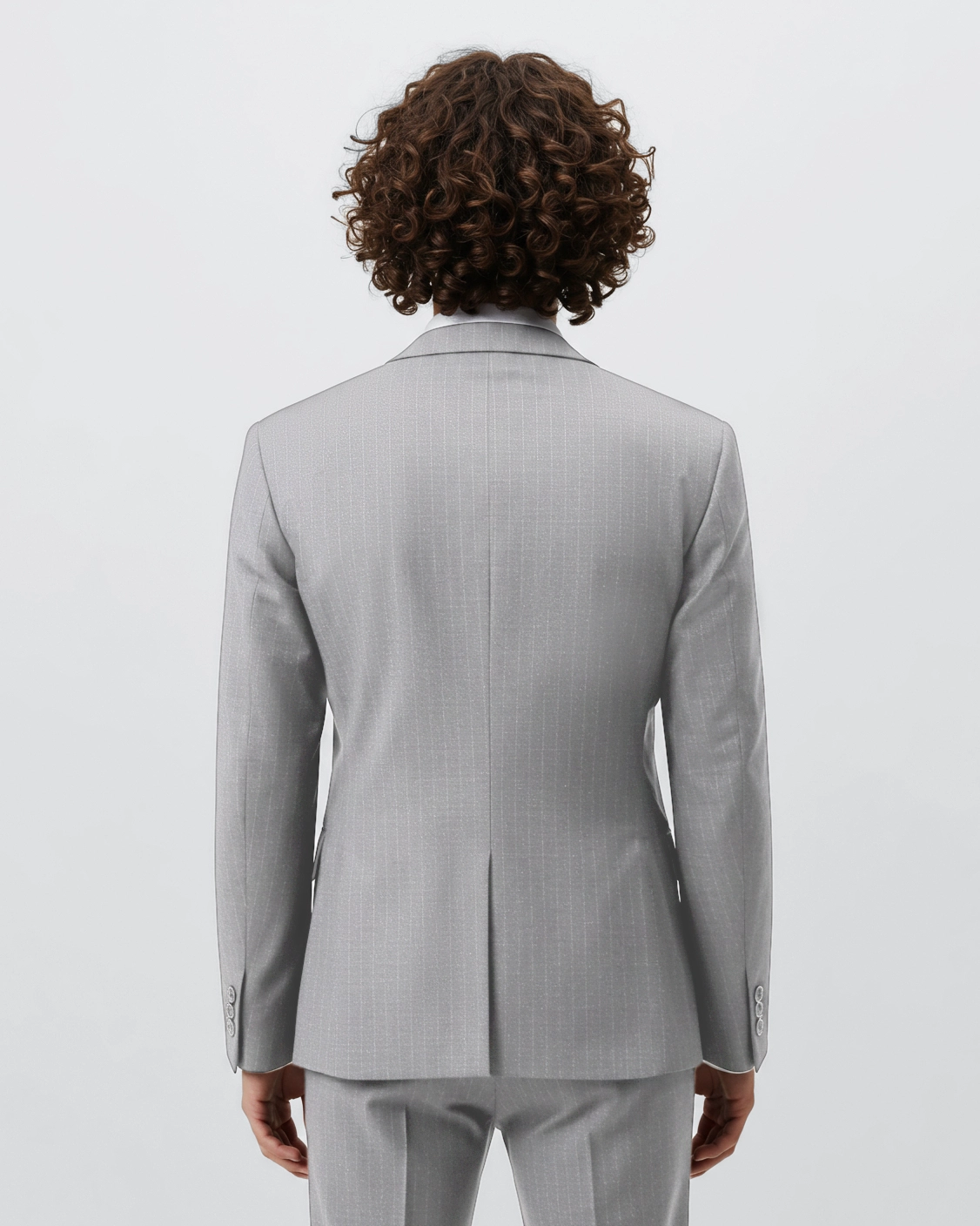 Rear view of a person in a light gray pinstripe suit jacket, showcasing modern fashion and curly hair.