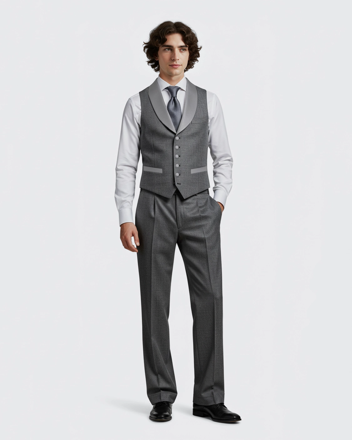 Man in a sharp gray formal vest and trousers with a white shirt and tie, showcasing elegant business attire.