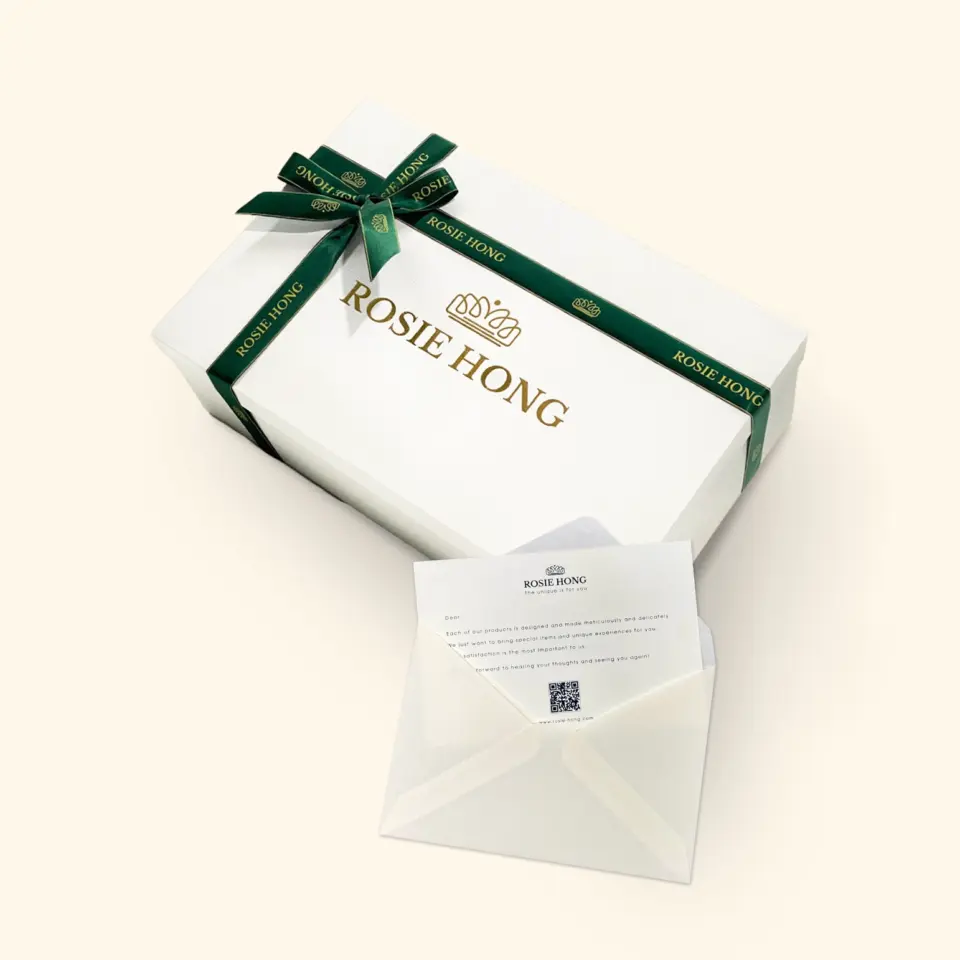 Elegant gift box with Rosie Hong logo and decorative green ribbon beside an open envelope with a letter.