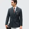 Man in tailored suit with accessories and holding a hat, looking left, stylish and elegant formal attire.