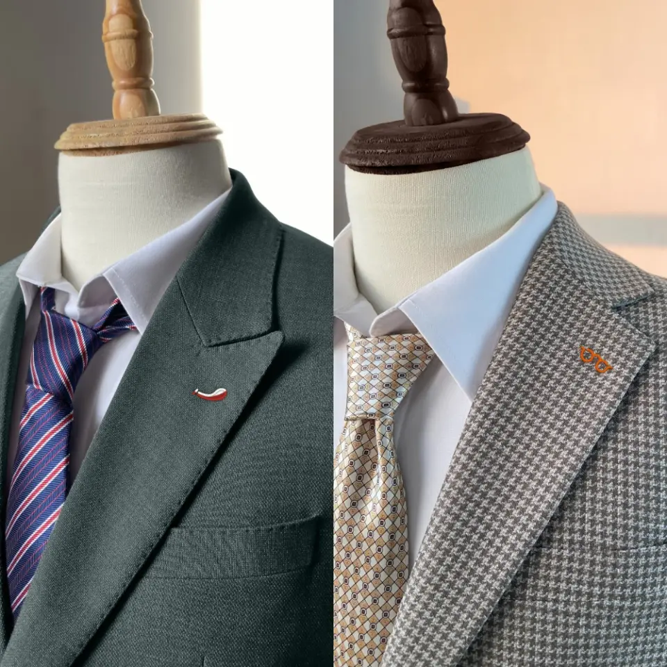 Two mannequins in stylish suits: one in solid gray with a striped tie, the other in a houndstooth pattern with a geometric tie.