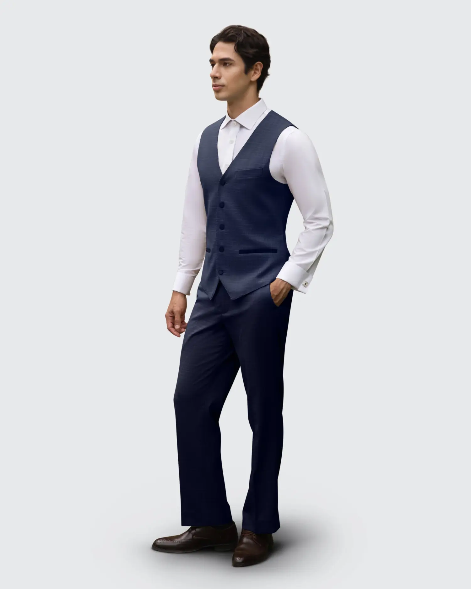 Man in stylish navy suit vest and trousers on a light grey background. Fashionable formal wear for special occasions.