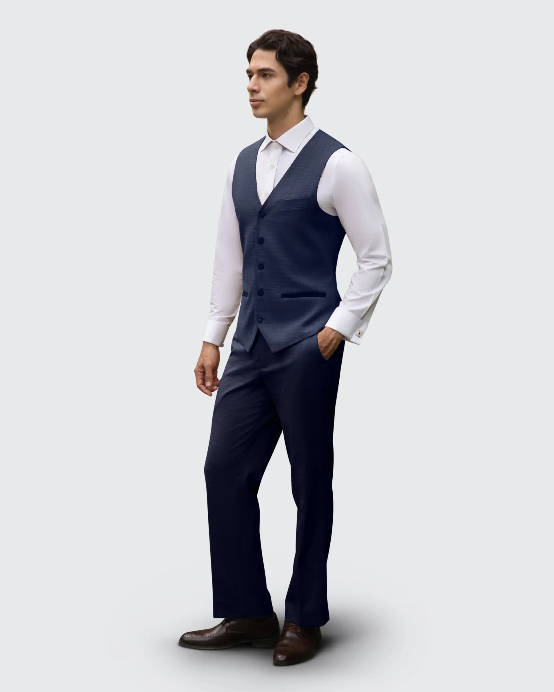 Man in stylish navy suit vest and trousers on a light grey background. Fashionable formal wear for special occasions.