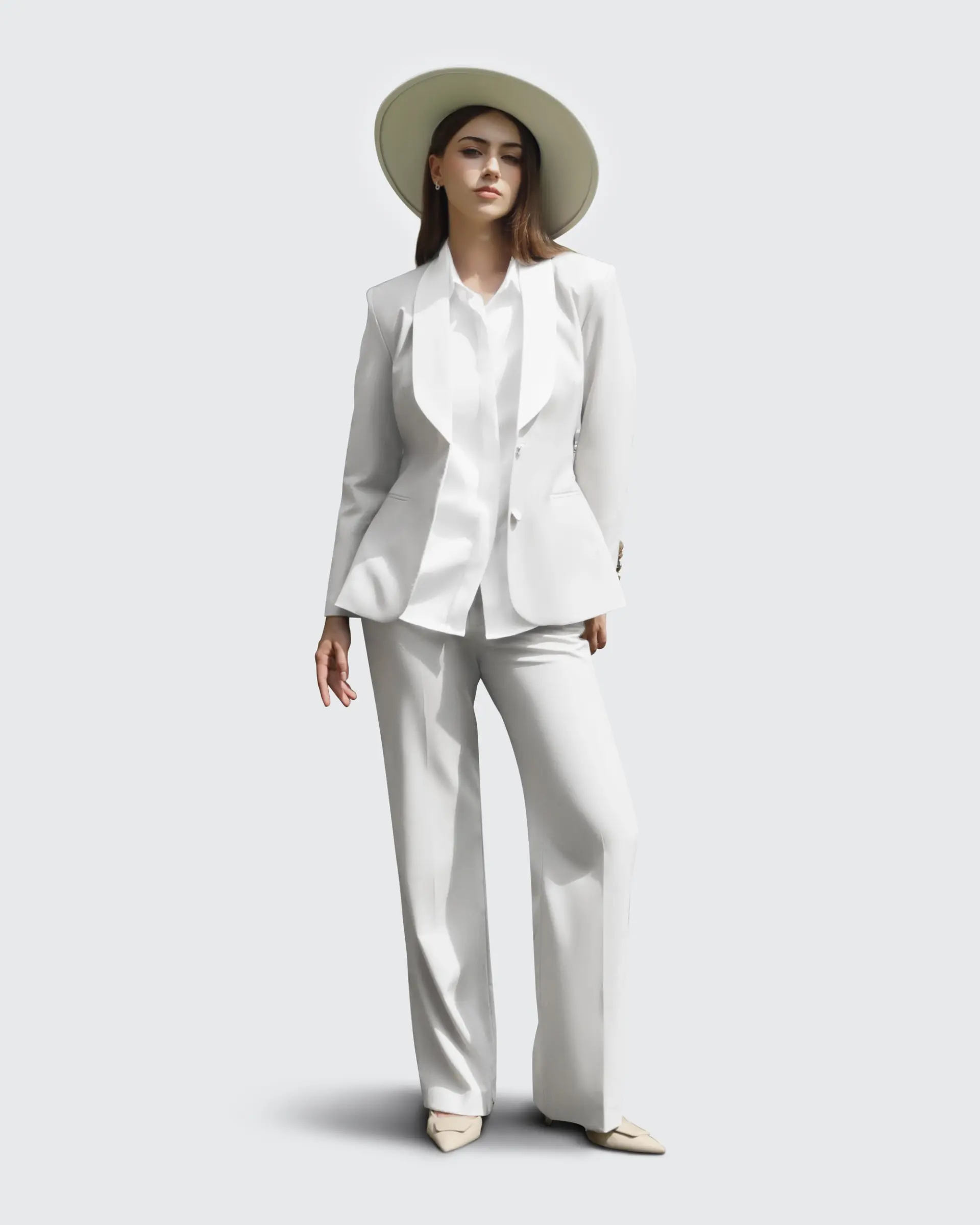 Woman in a stylish white suit and wide-brimmed hat, posing confidently against a light background.