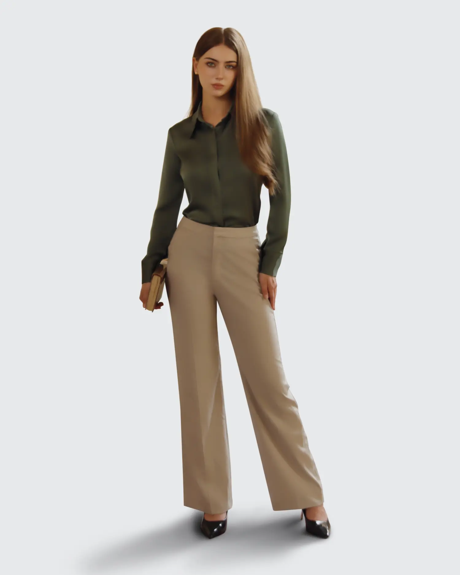 Woman in professional attire holding a book; wearing green blouse and beige trousers. Business fashion concept.