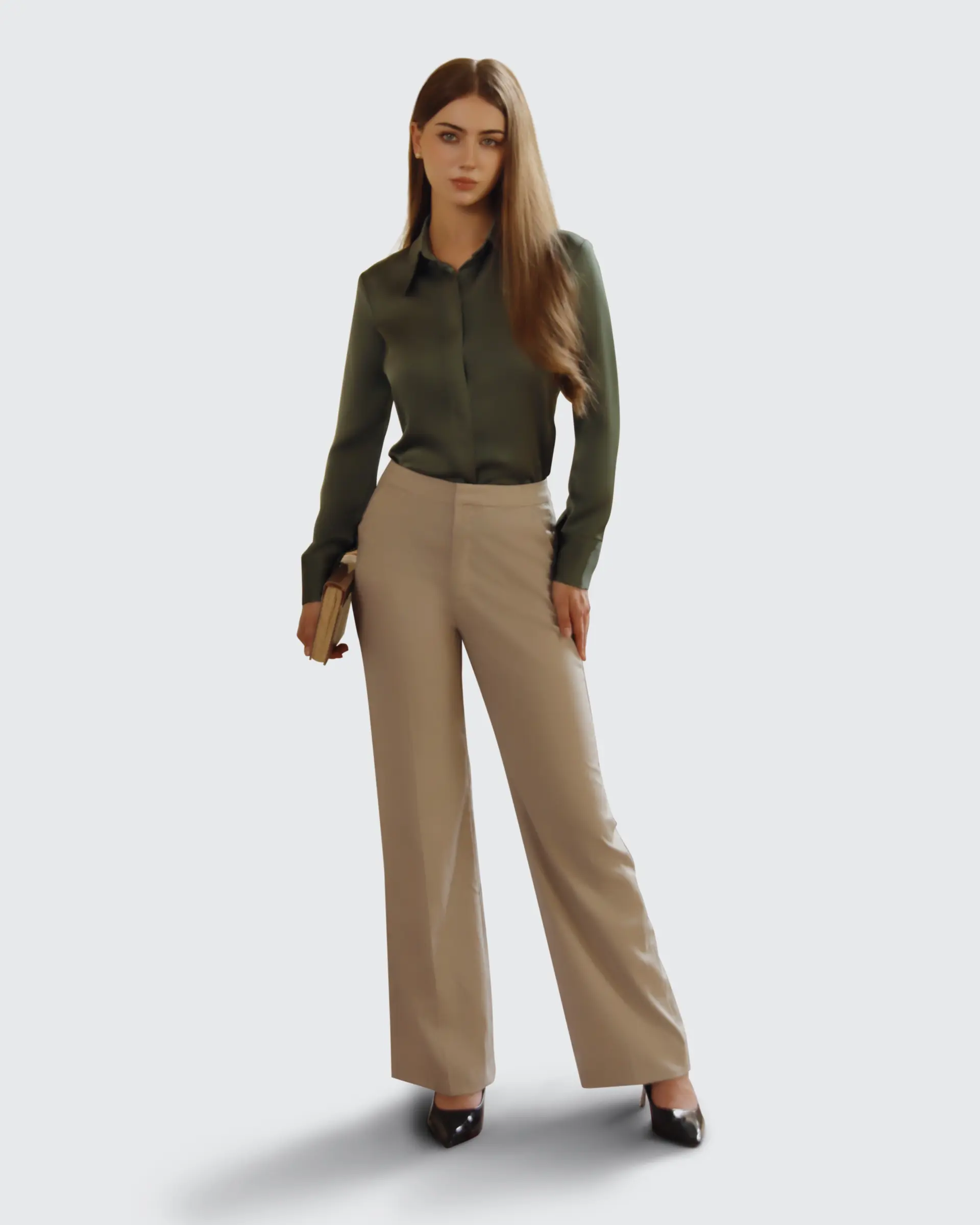 Woman in professional attire holding a book; wearing green blouse and beige trousers. Business fashion concept.