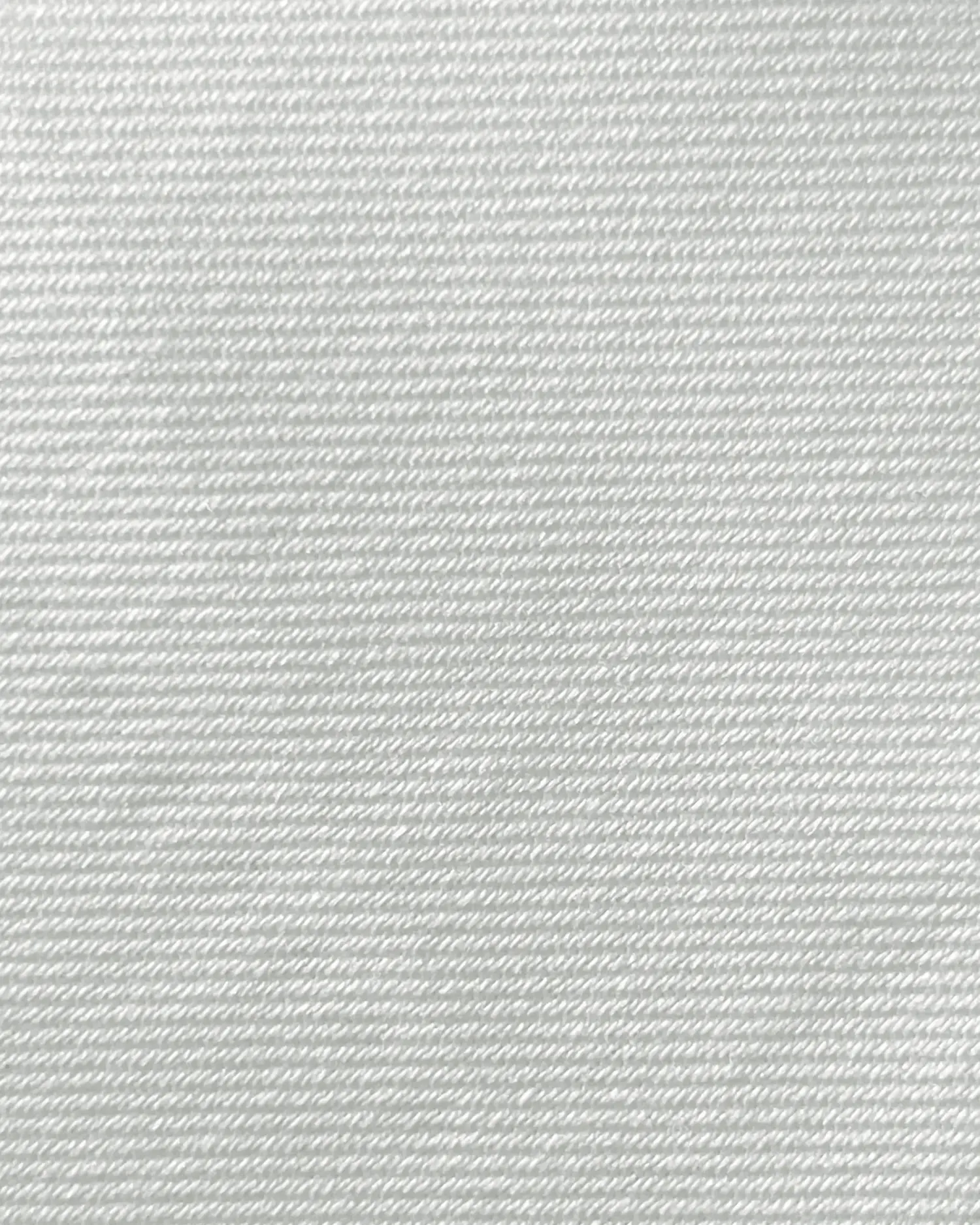 Close-up of white twill fabric texture with diagonal weave pattern.
