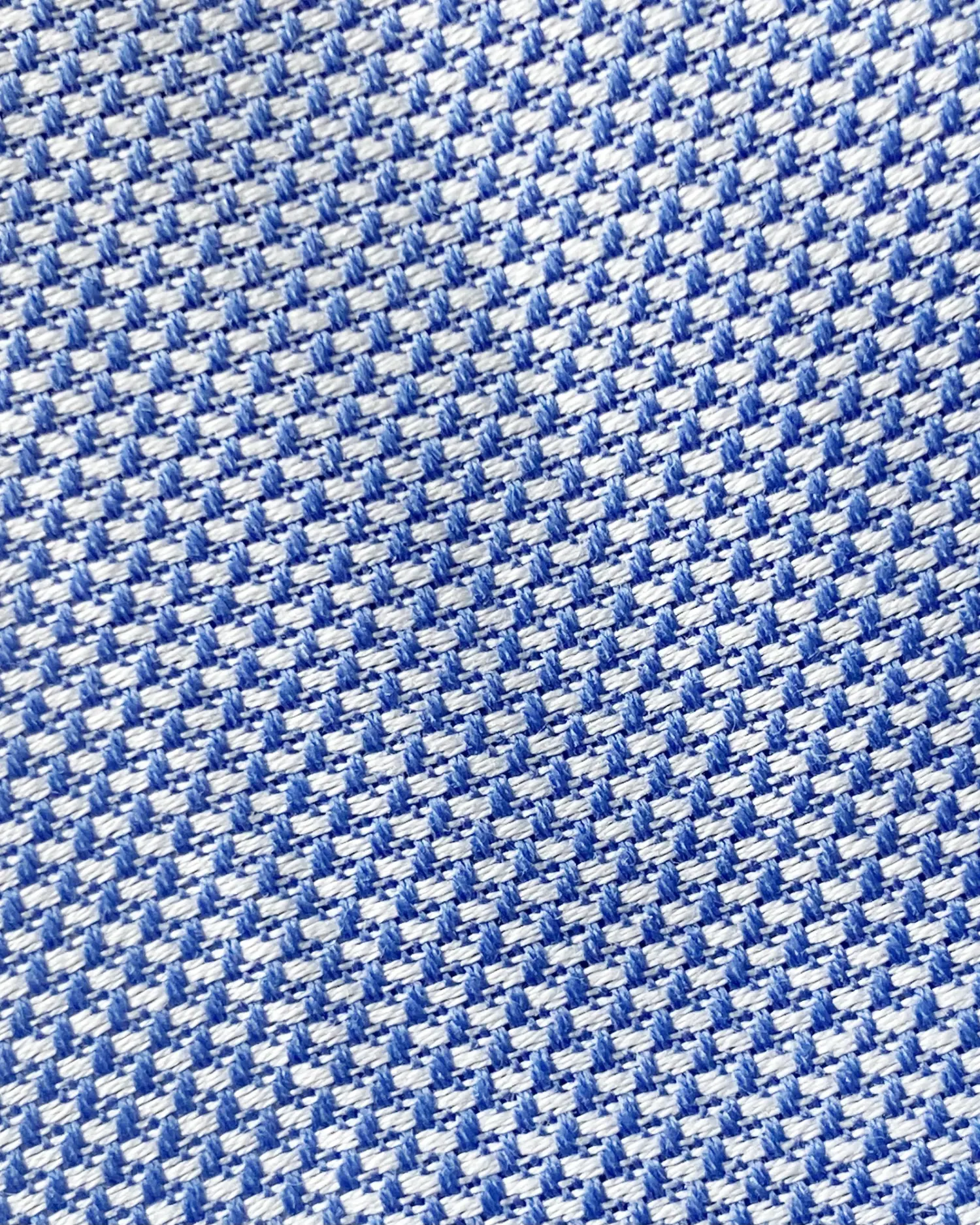 Close-up of blue and white houndstooth fabric pattern, showing detailed texture and design.