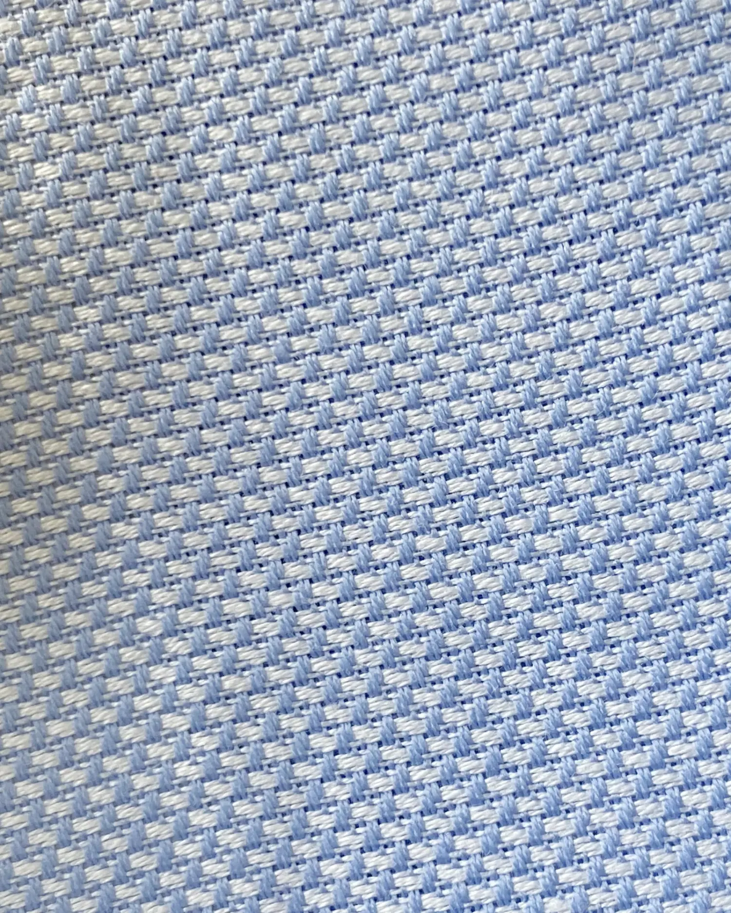 Close-up of light blue textured fabric with a woven pattern.
