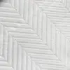 Close-up of white herringbone pattern on fabric, showcasing textured diagonal lines for a sophisticated design.