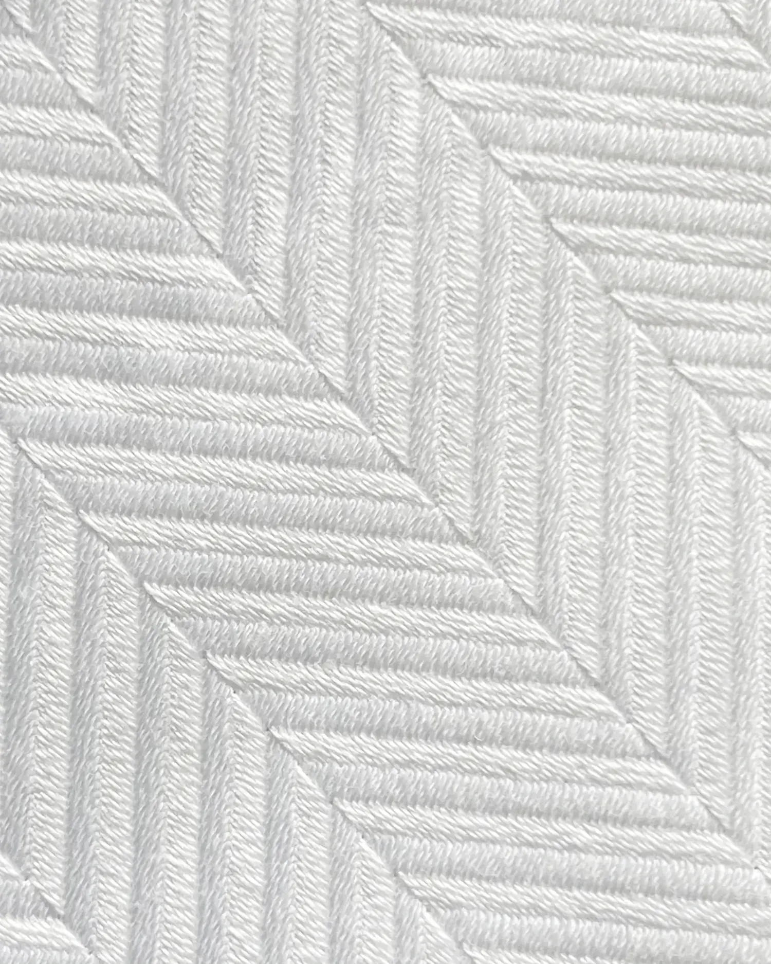 Close-up of white herringbone pattern on fabric, showcasing textured diagonal lines for a sophisticated design.