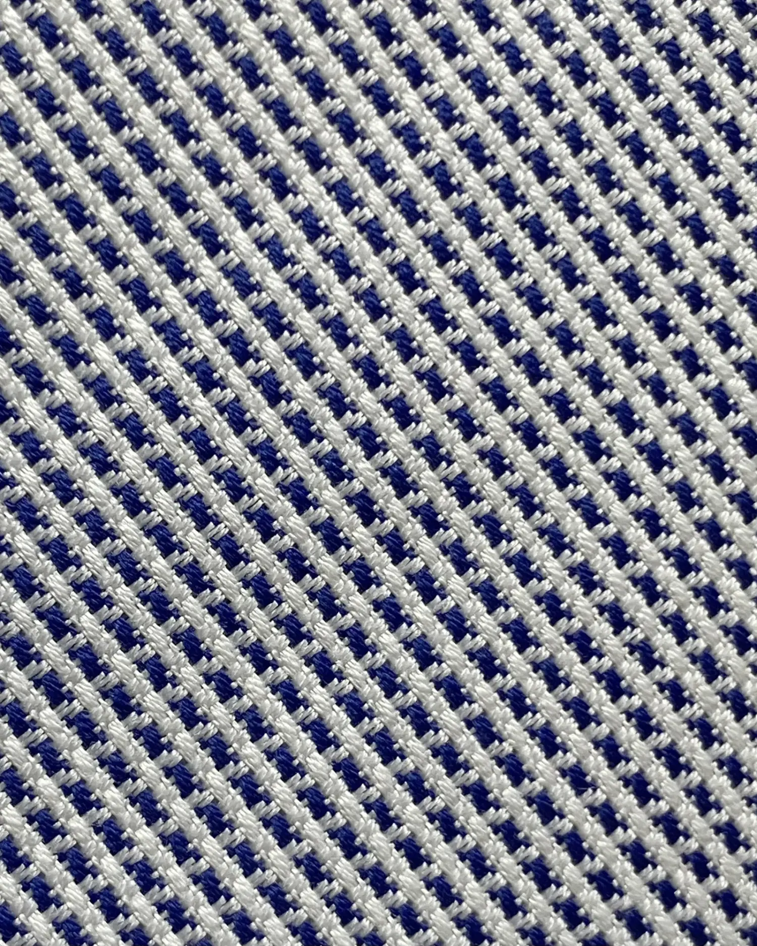 Close-up of a textured blue and white mesh fabric, showcasing a detailed woven pattern.