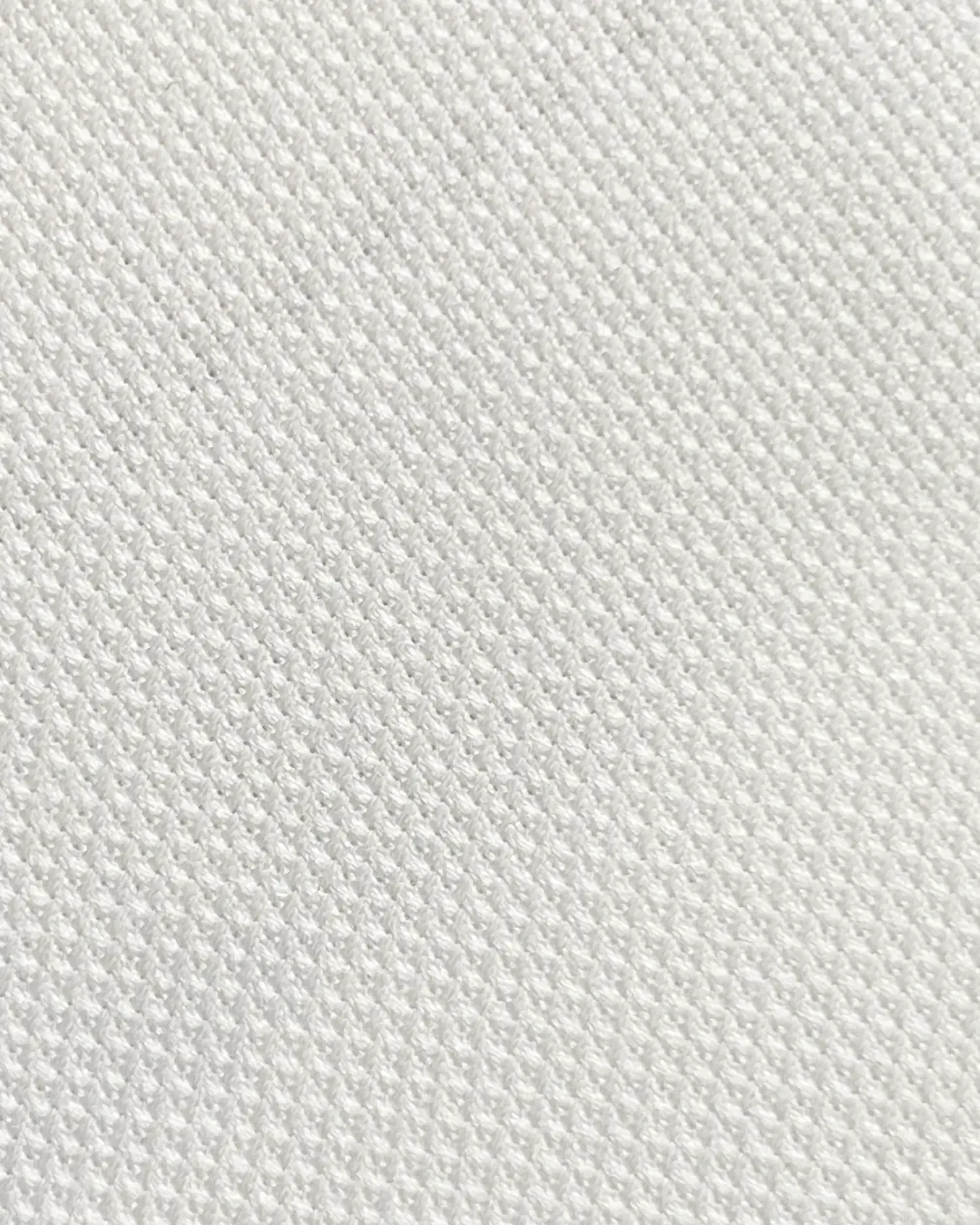 Close-up of white textured fabric, showcasing intricate weave pattern for design and material analysis.