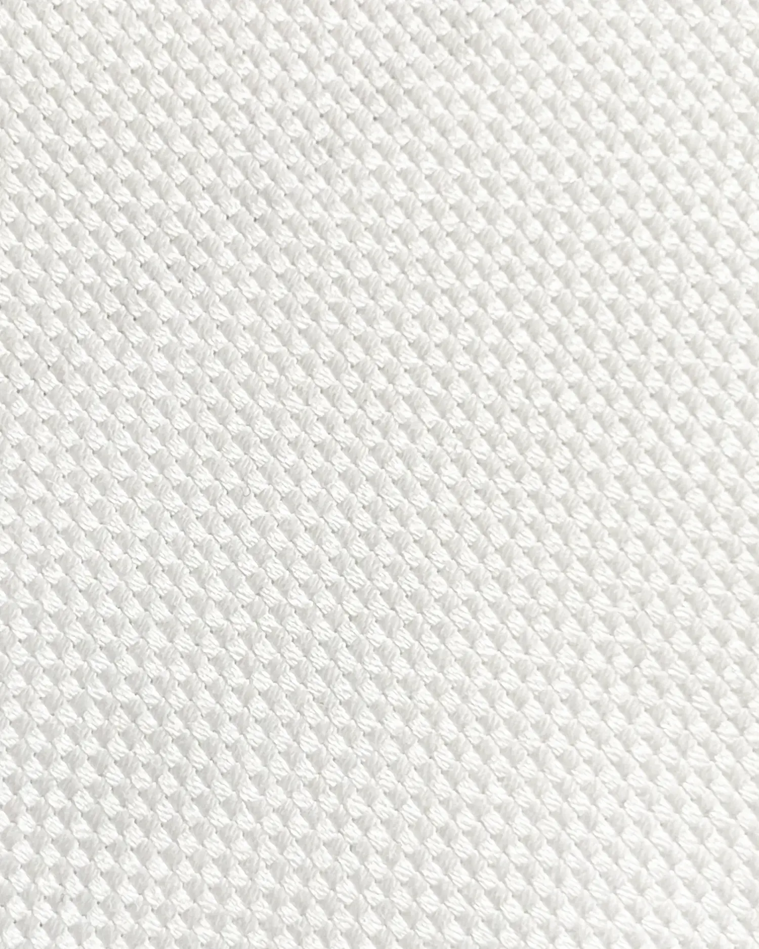Close-up of a textured white fabric pattern, showcasing the intricate weave and durability of the material.