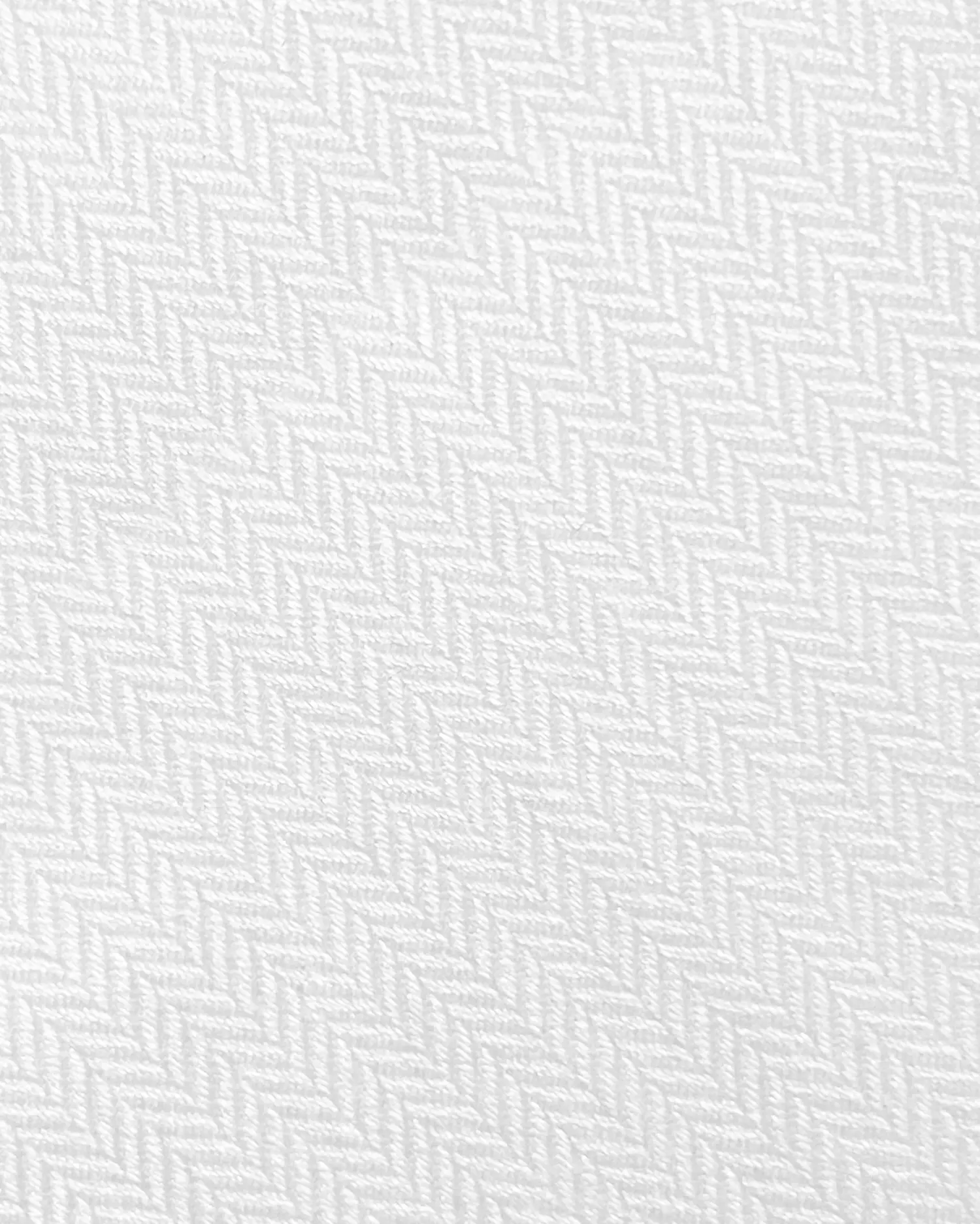 Close-up of white textured herringbone fabric pattern, emphasizing intricate weave design and soft textile detail.
