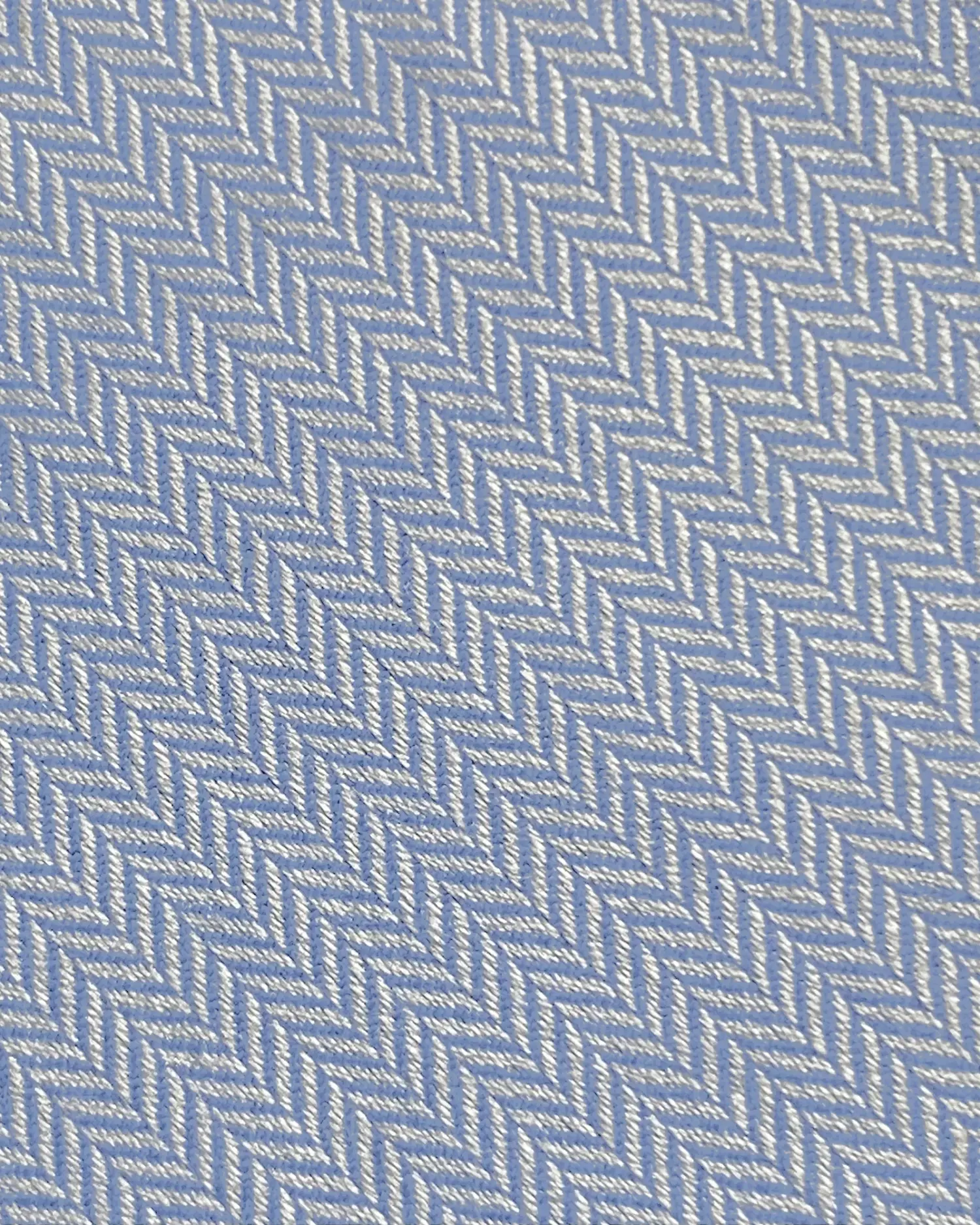 Close-up of a blue and gray herringbone fabric pattern with textured details.