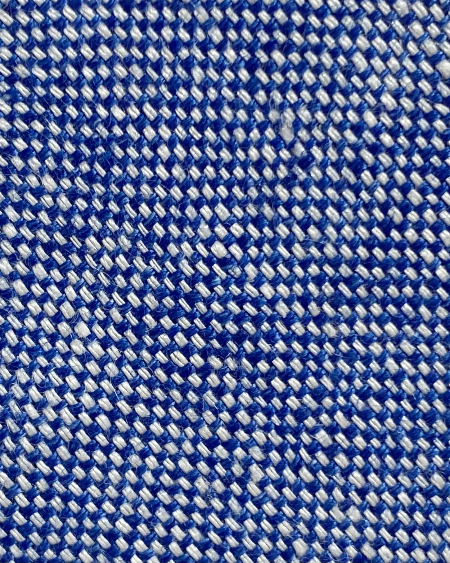 Close-up of blue and white woven fabric texture, showcasing intricate pattern and textile detail.