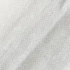 Close-up of textured white fabric with a woven pattern, showcasing textile detail and quality.