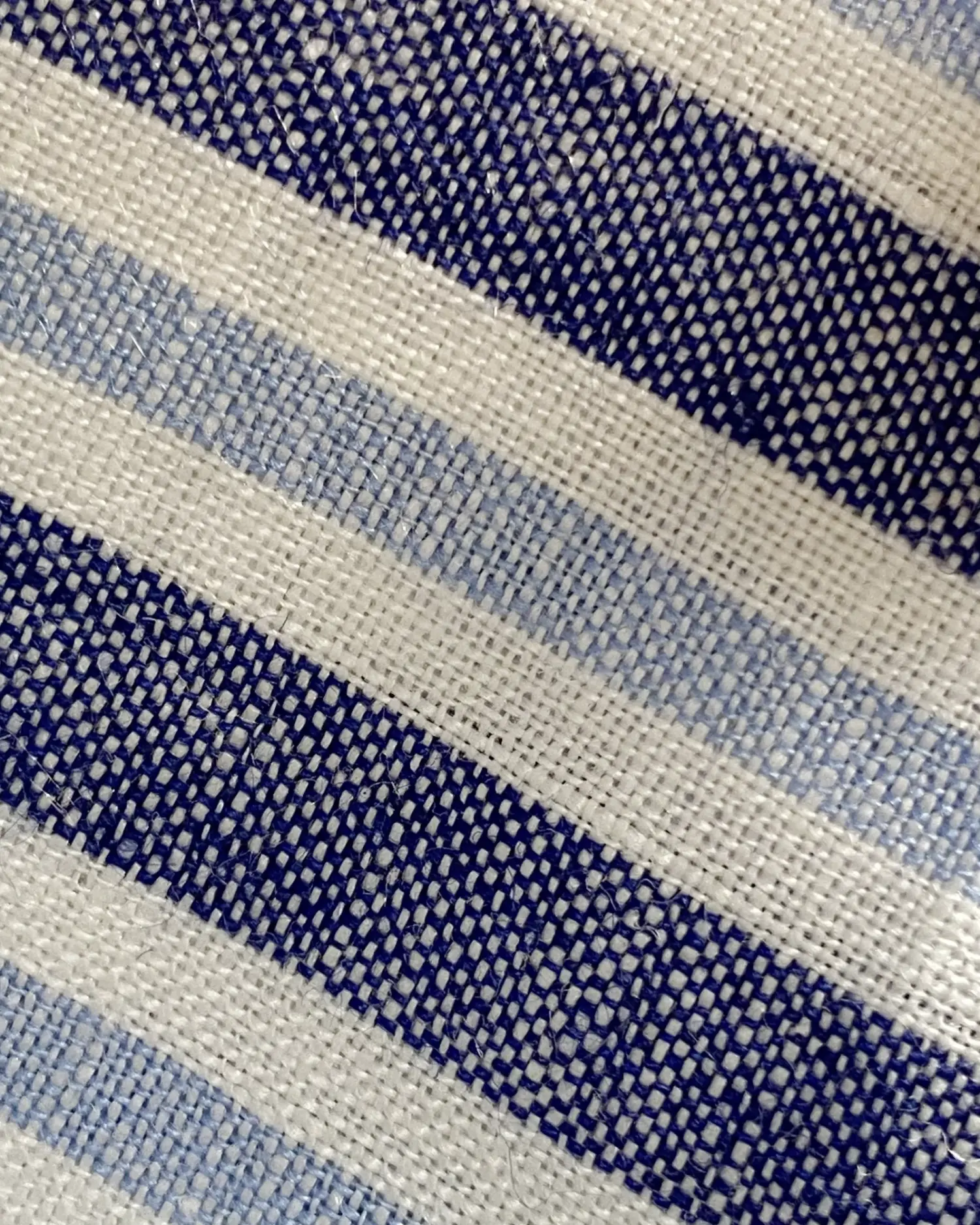 Close-up of blue and white striped woven fabric texture for fashion or interior design.