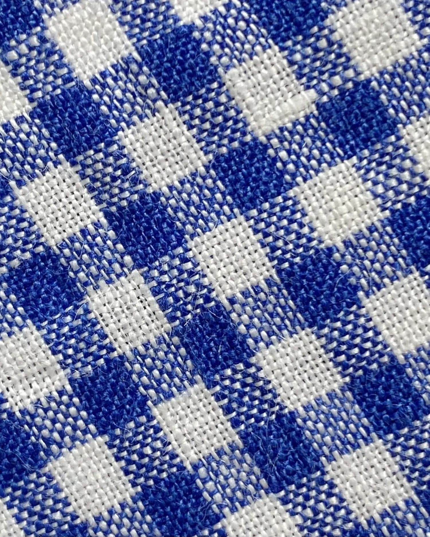 Close-up of blue and white gingham fabric pattern showing detailed woven texture.