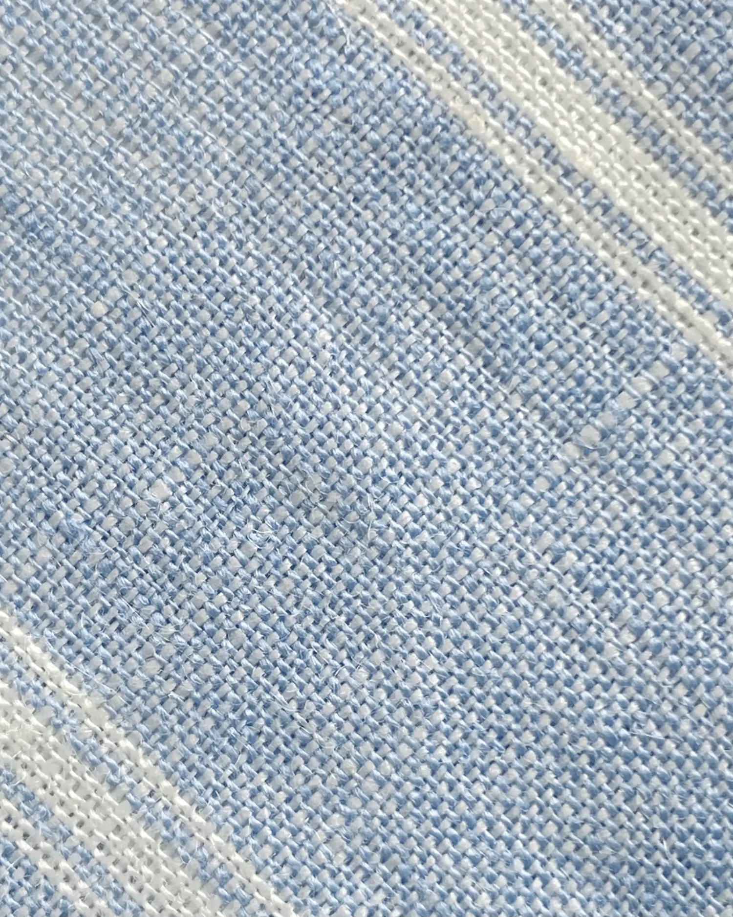 Close-up of textured blue and white woven fabric with diagonal patterns.