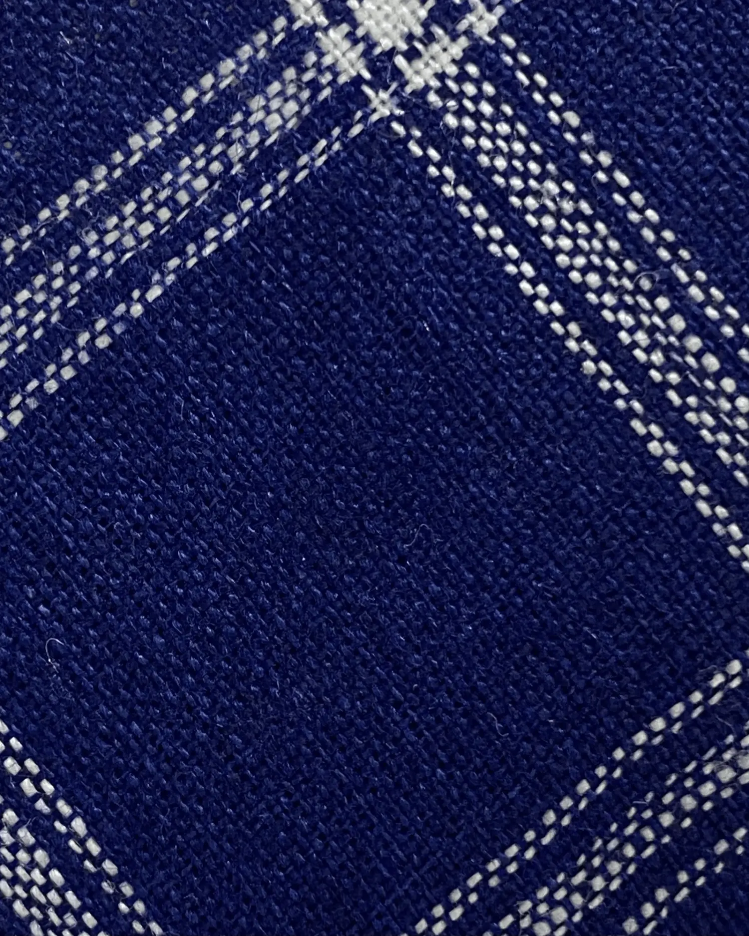 Navy blue and white checkered fabric texture, close-up view of woven textile pattern.