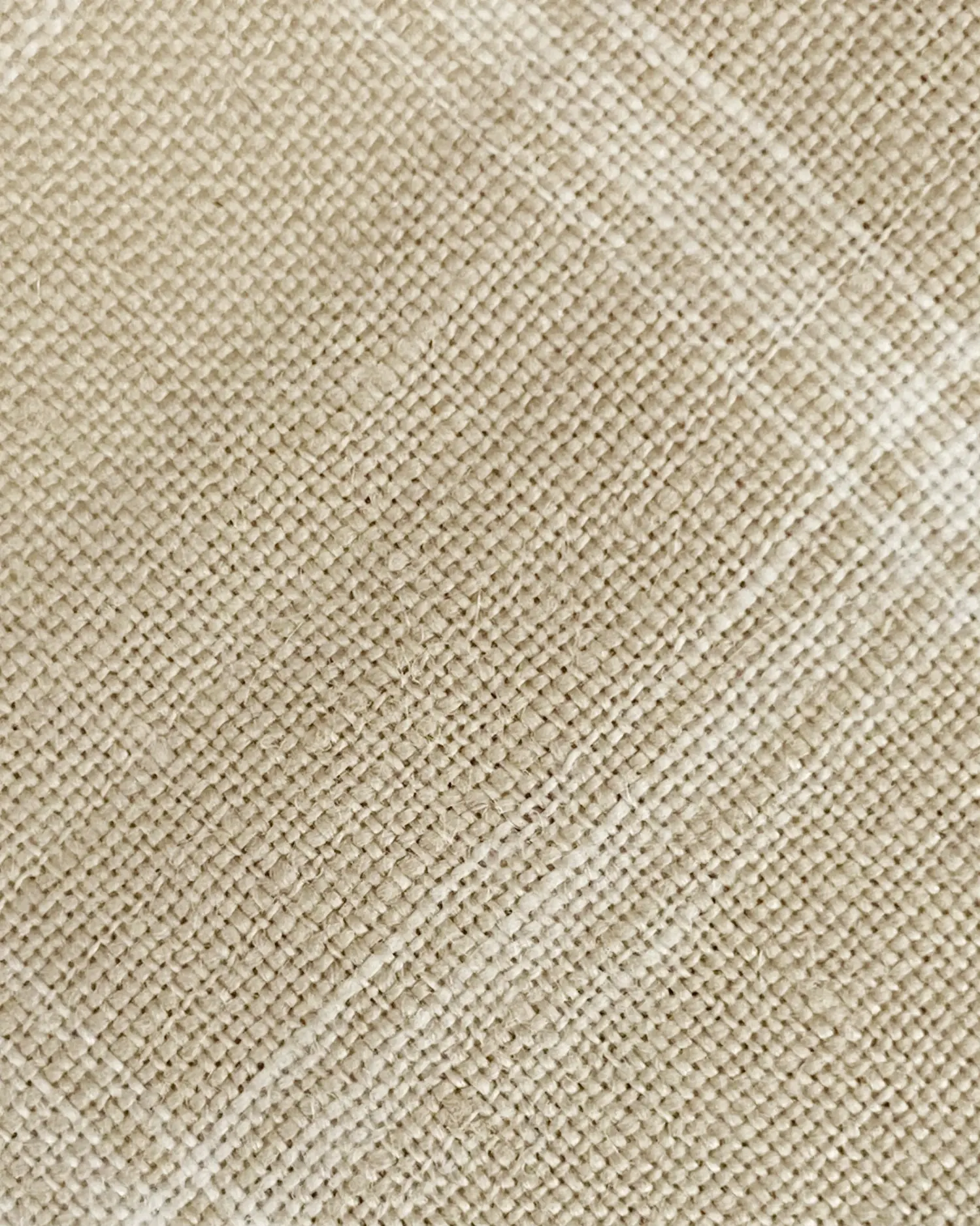 Close-up of a textured beige burlap fabric with woven pattern, ideal for crafts and rustic decor.