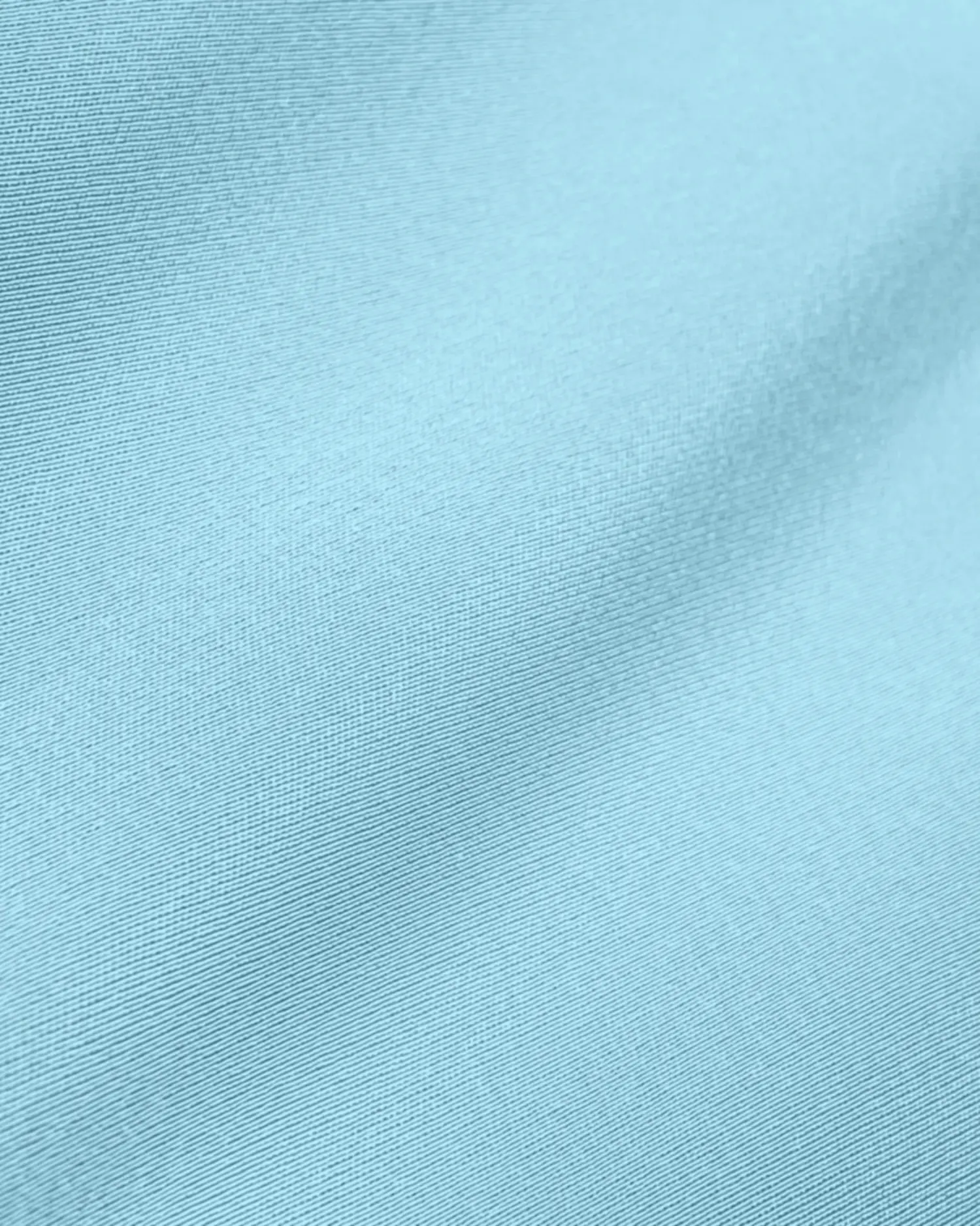 Light blue fabric texture with soft lighting, showcasing smooth, woven material. Ideal for clothing or interior design.