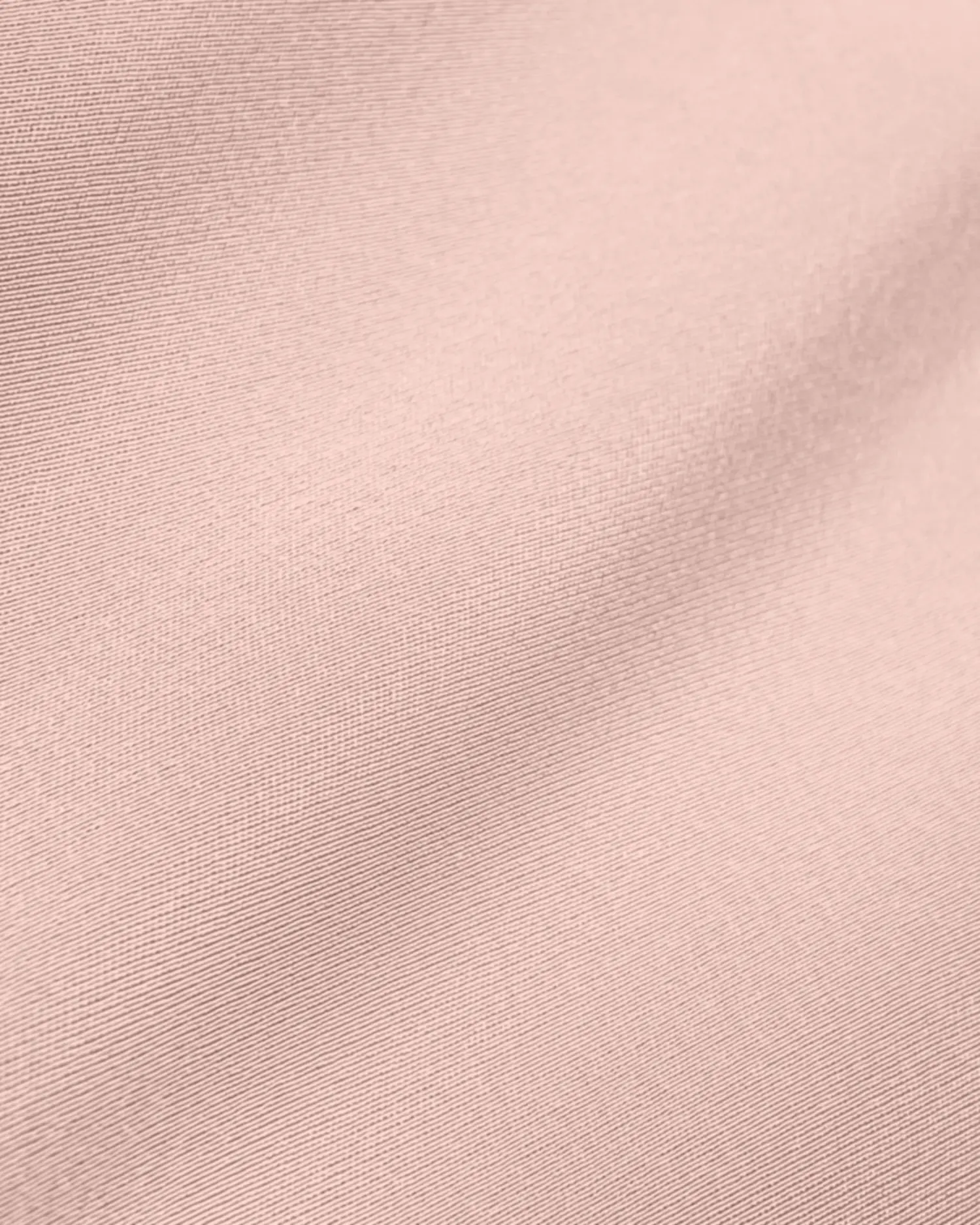 Close-up view of smooth blush pink fabric, showcasing its fine texture and soft drape.