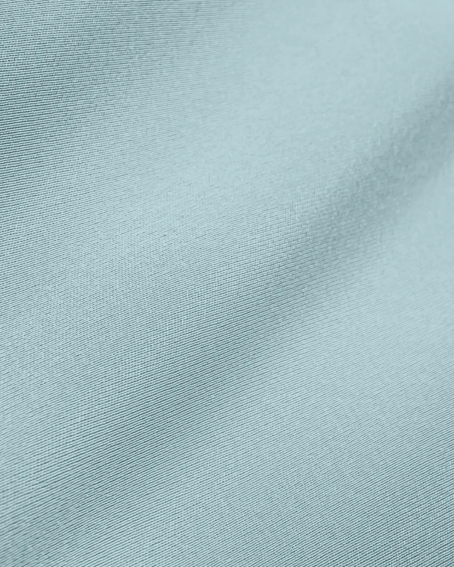 Close-up of smooth light blue fabric texture, showcasing fine weave and subtle sheen.