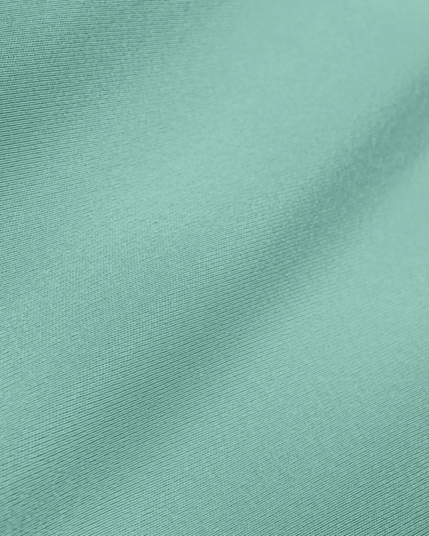 Close-up of light blue-green fabric texture with subtle folds and detailed weave pattern.