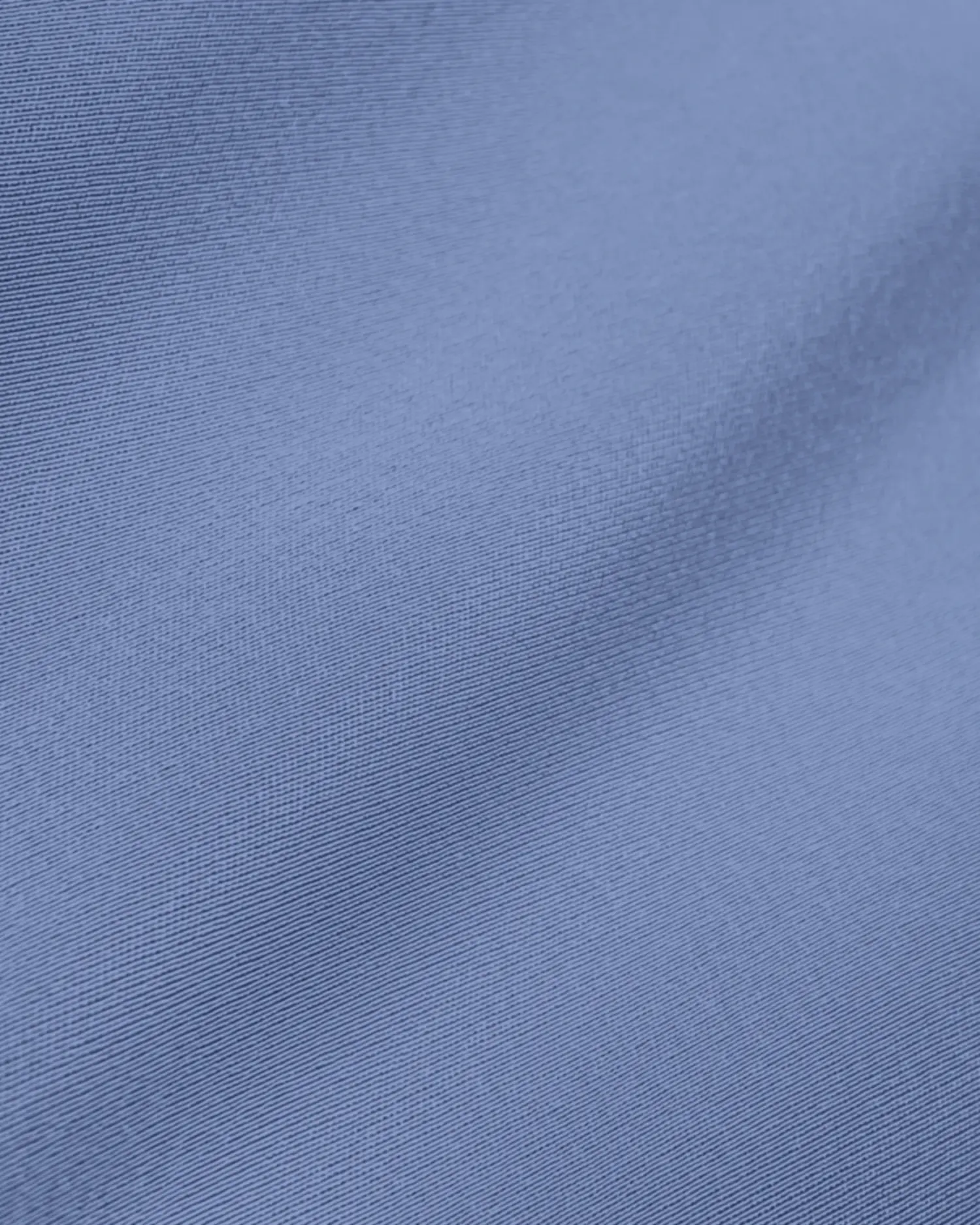 Close-up of smooth blue fabric texture with subtle folds, showcasing textile quality and color for fashion design.