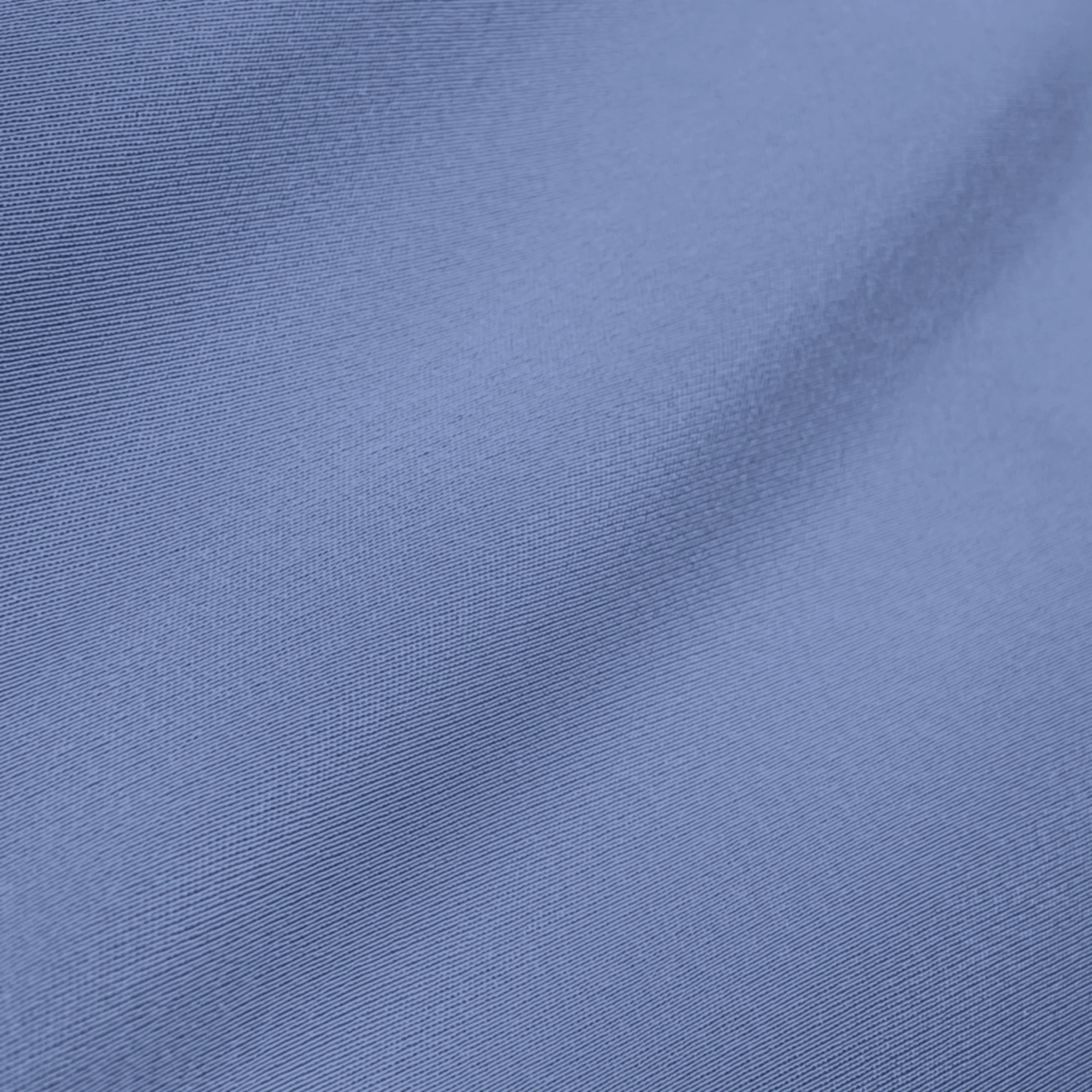 Close-up of smooth blue fabric texture with subtle folds, showcasing textile quality and color for fashion design.