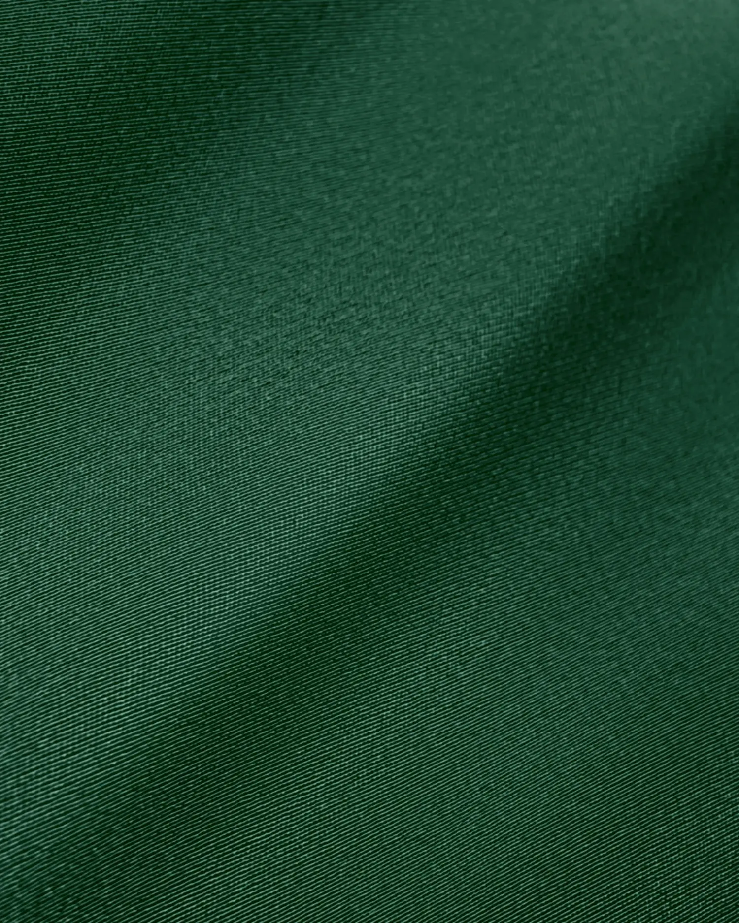 Smooth green fabric texture with soft, subtle folds and a silky sheen. Ideal for textiles and design inspiration.