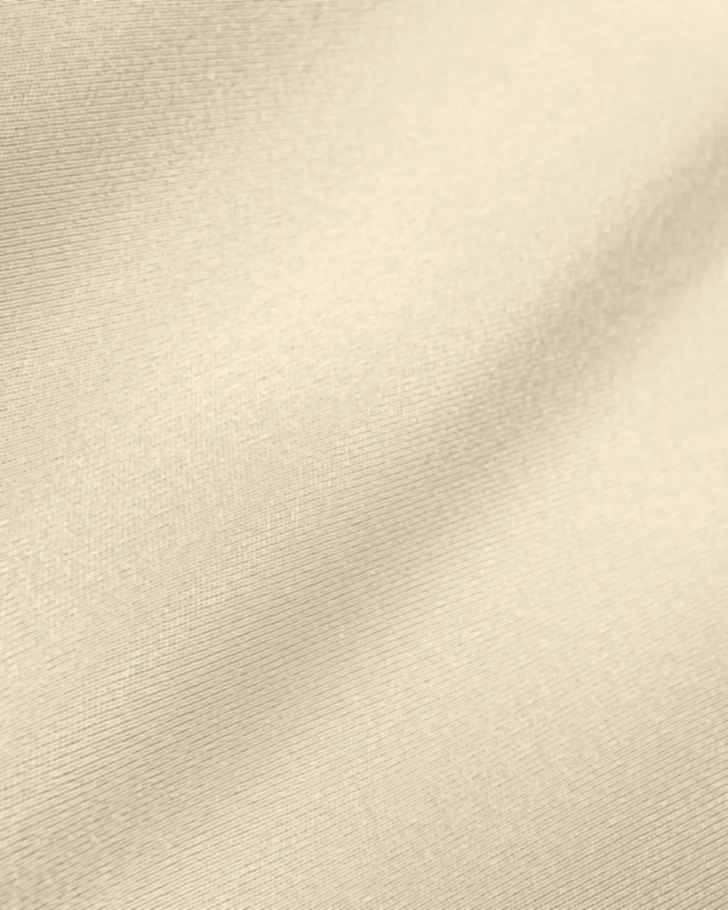 Close-up of smooth beige fabric texture with subtle shadows, emphasizing soft and elegant material appearance.