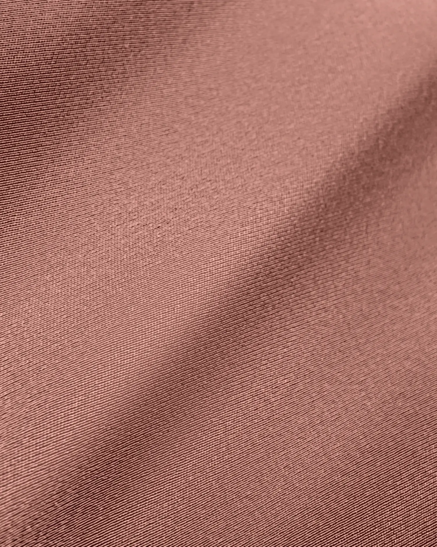 Close-up view of textured brown fabric with subtle sheen and diagonal crease, highlighting the weave detail.