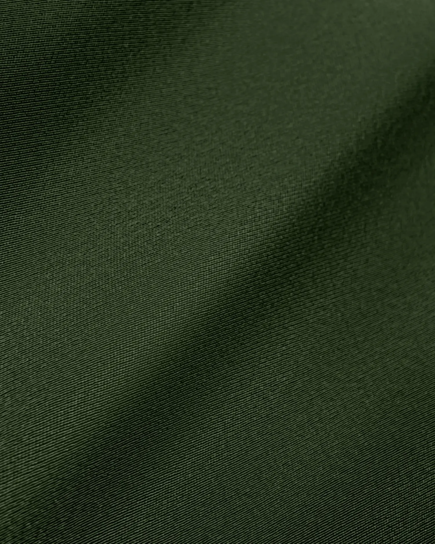 Dark green fabric texture with subtle lighting, ideal for backgrounds or textile design inspiration.