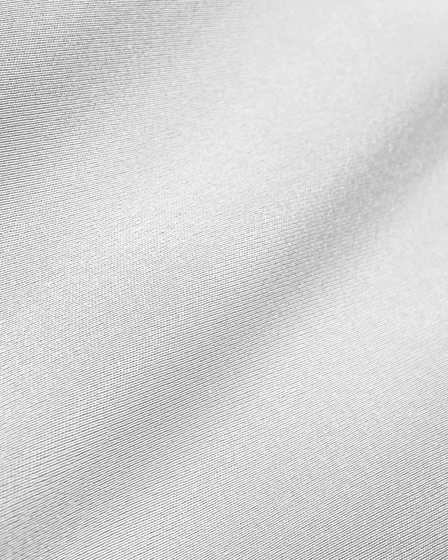 Close-up of smooth, white fabric texture with subtle shadows creating a wavy appearance. Ideal for backgrounds or textile design.
